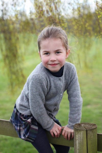 Princesa Charlotte sentada em uma cerca